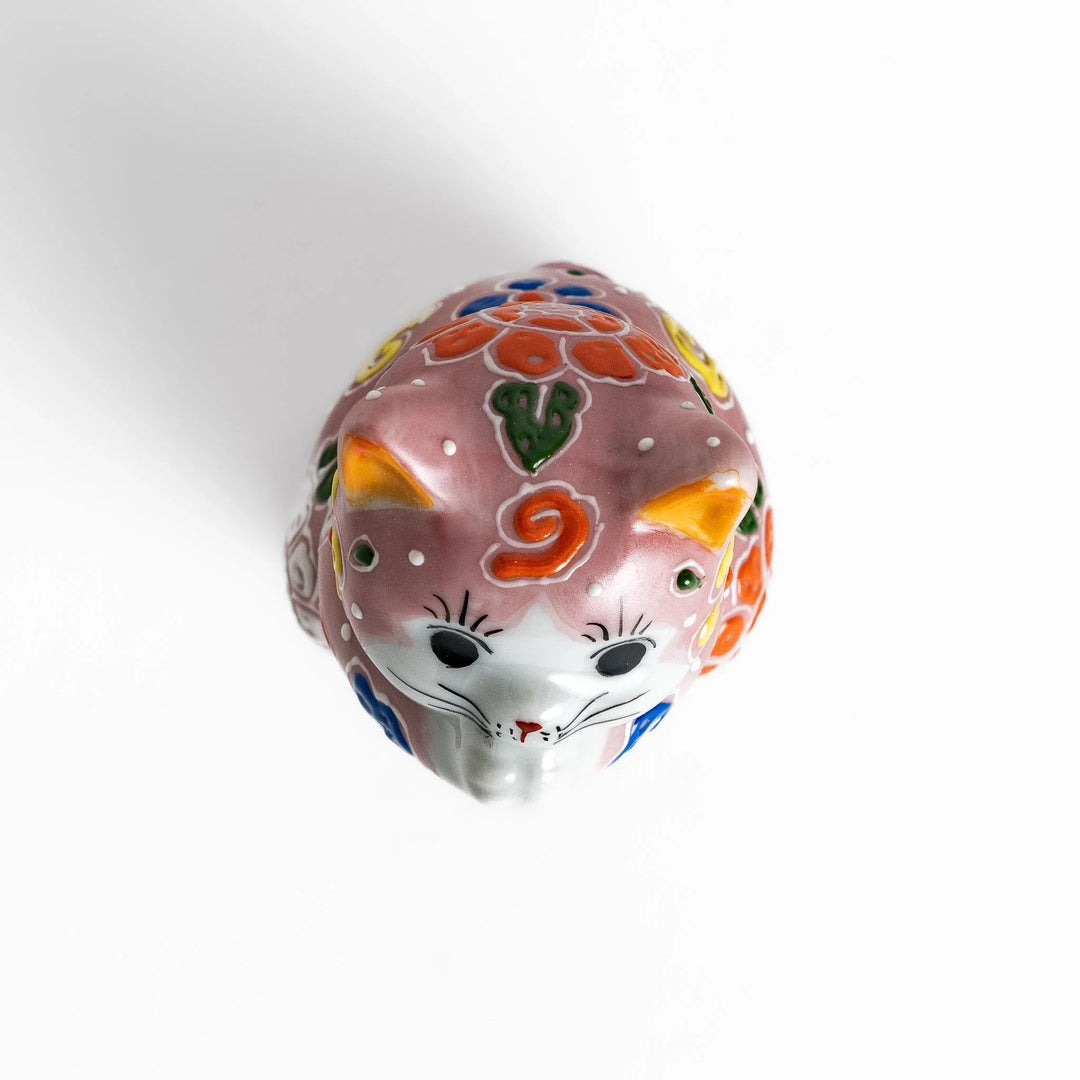 Maneki Neko figurine featuring a pink blossom design with vibrant colors and a praying posture for good fortune.