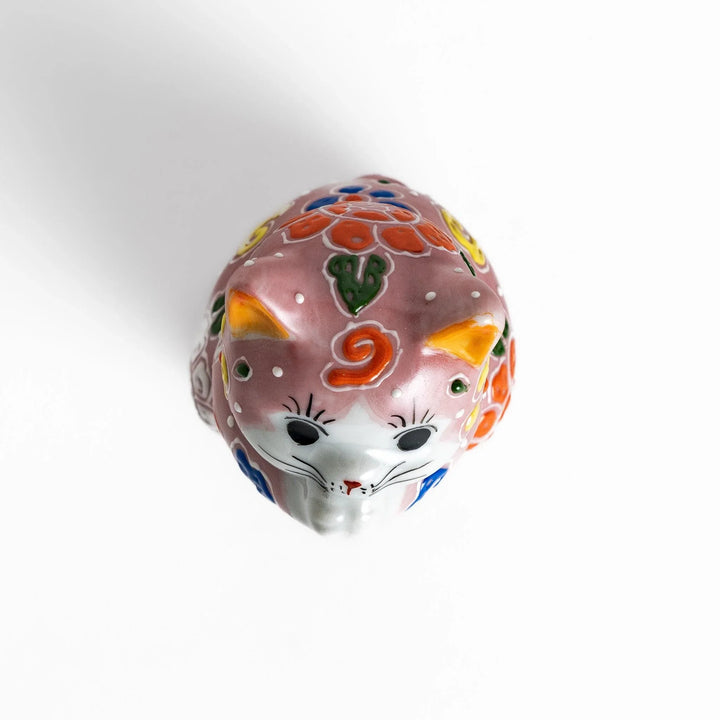 Maneki Neko figurine featuring a pink blossom design with vibrant colors and a praying posture for good fortune.