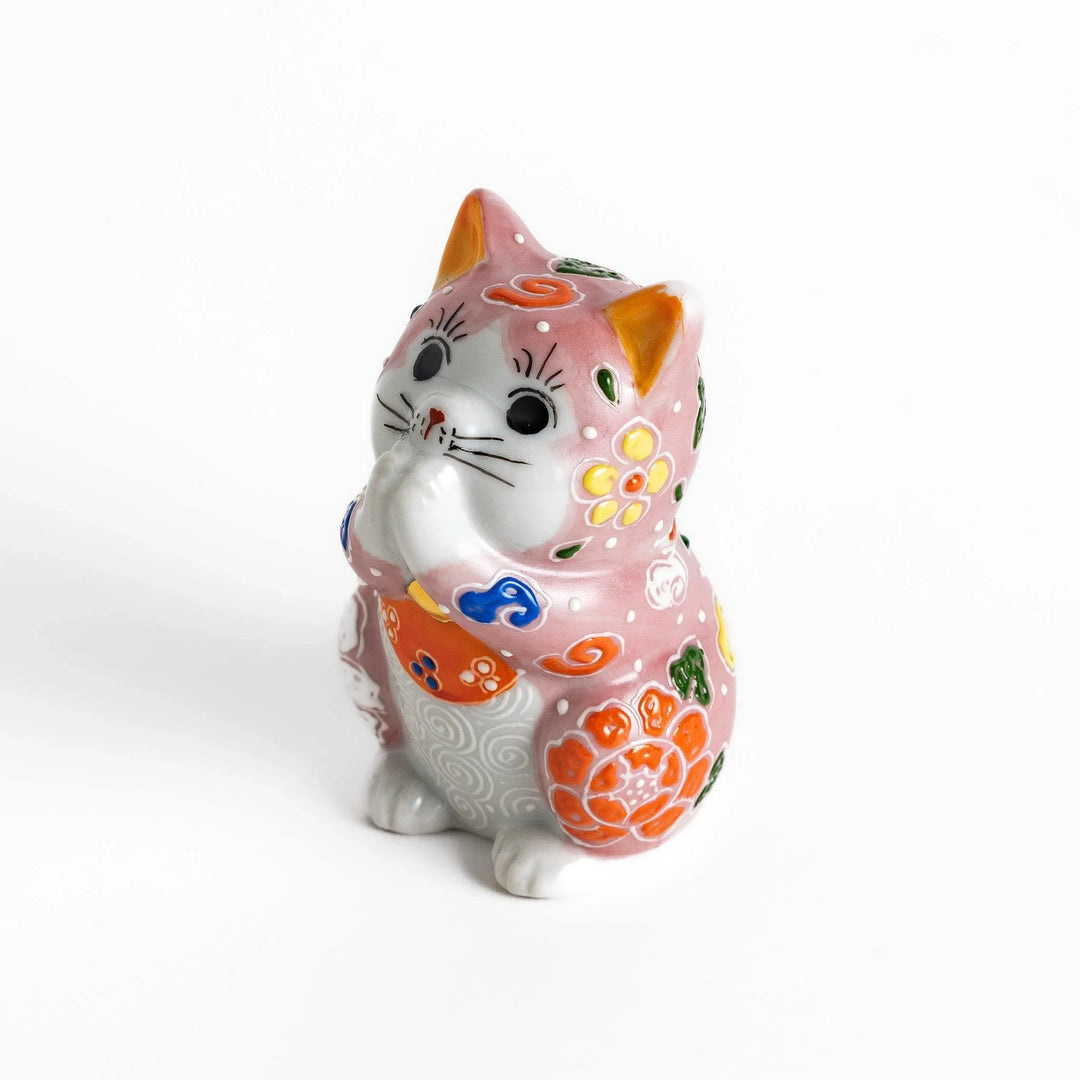 Maneki Neko figurine featuring a pink blossom design with vibrant colors and a praying posture for good fortune.