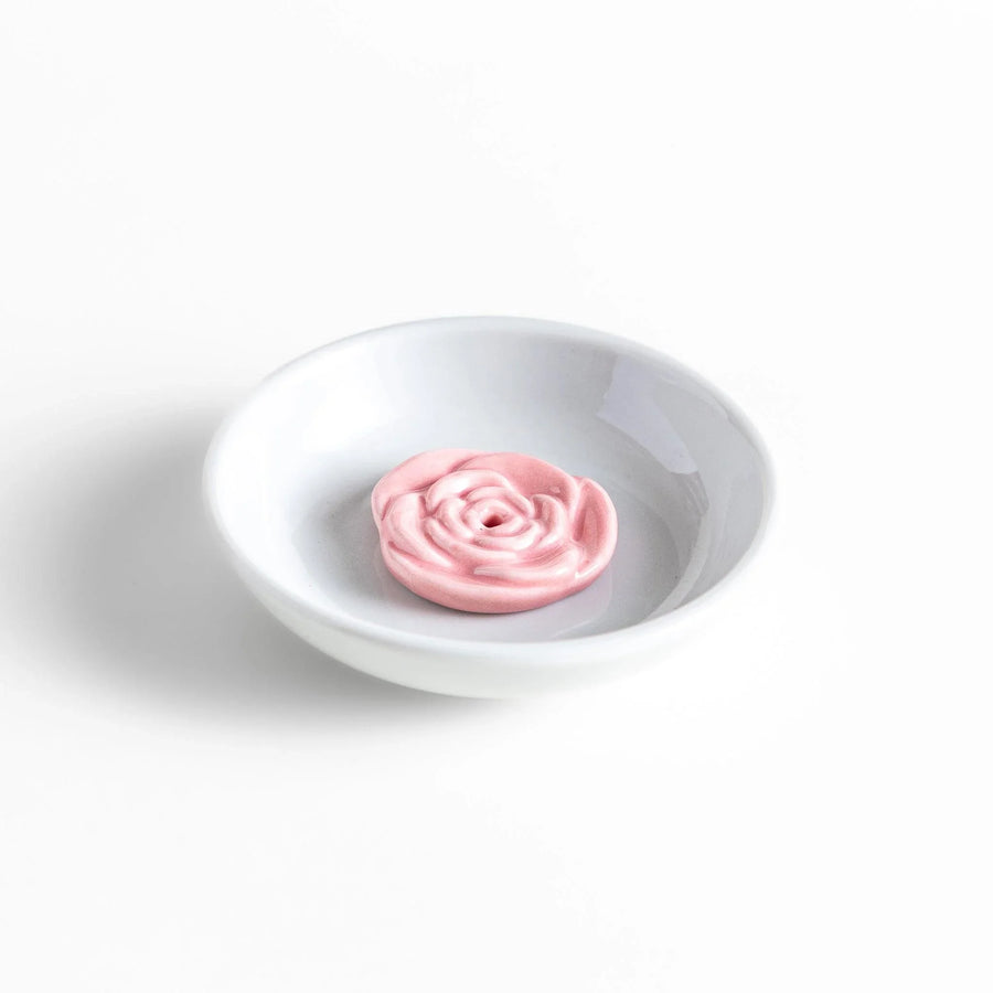 White ceramic Japanese incense holder with pink rose design adding elegant floral touch to any space.
