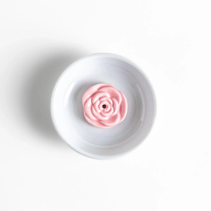 White ceramic Japanese incense holder with pink rose design adding elegant floral touch to any space.