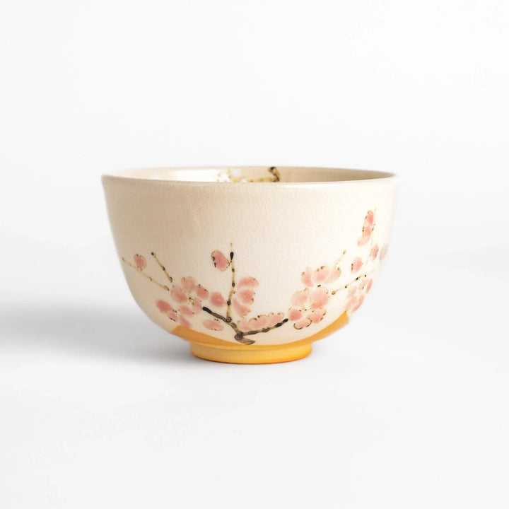 Plum Blossom Matcha Bowl with pink floral designs on a cream surface, adding elegance to your matcha moments.