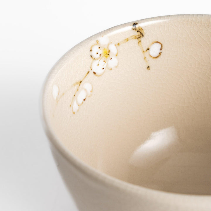 Plum Blossom Matcha Bowl with pink floral designs on a cream surface, adding elegance to your matcha moments.