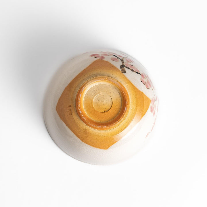 Plum Blossom Matcha Bowl with pink floral designs on a cream surface, adding elegance to your matcha moments.