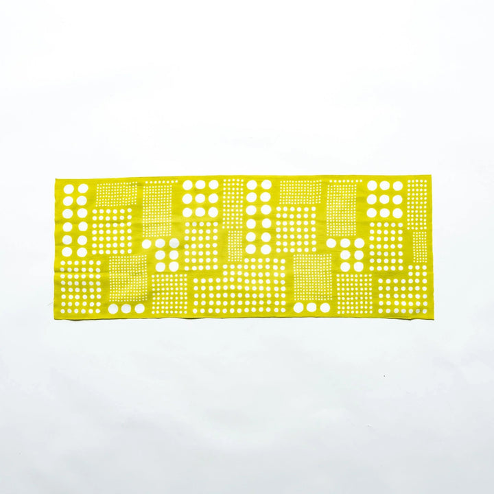 Yellow green polka dot tenugui hand towel laid flat, showcasing the crisp white dot design.
