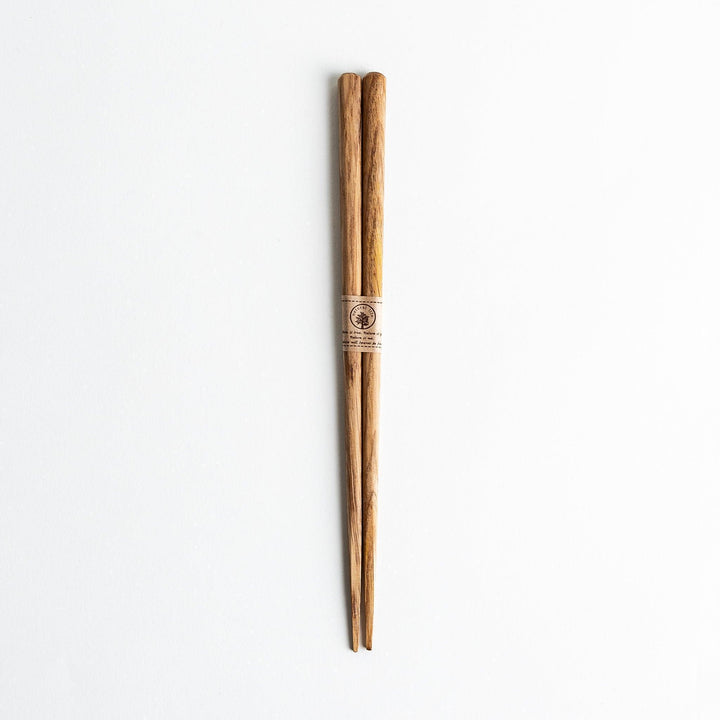Three pairs of natural chestnut wood chopsticks, each with a different geometric shape—triangle, hexagon, and round.