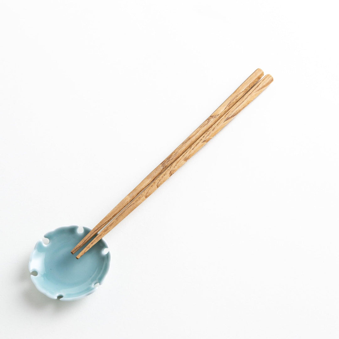 Three pairs of natural chestnut wood chopsticks, each with a different geometric shape—triangle, hexagon, and round.