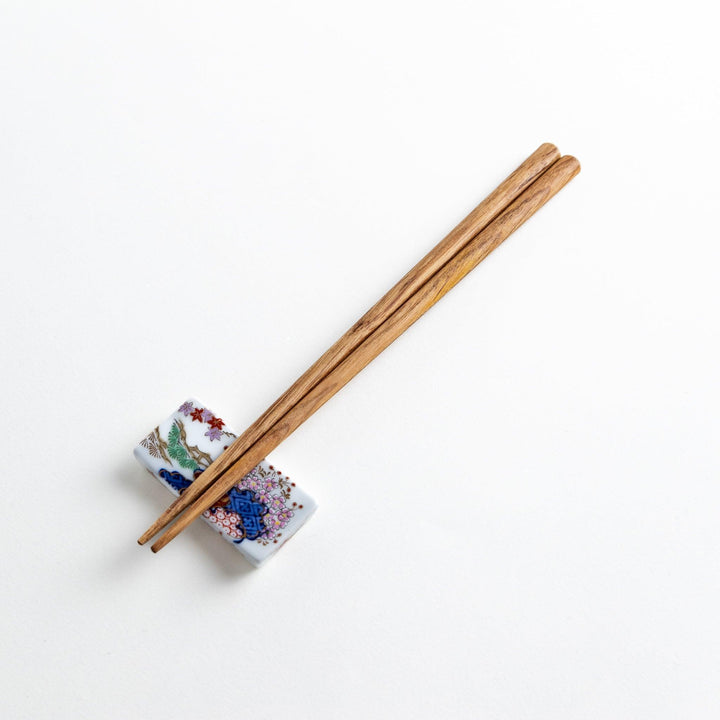Three pairs of natural chestnut wood chopsticks, each with a different geometric shape—triangle, hexagon, and round.
