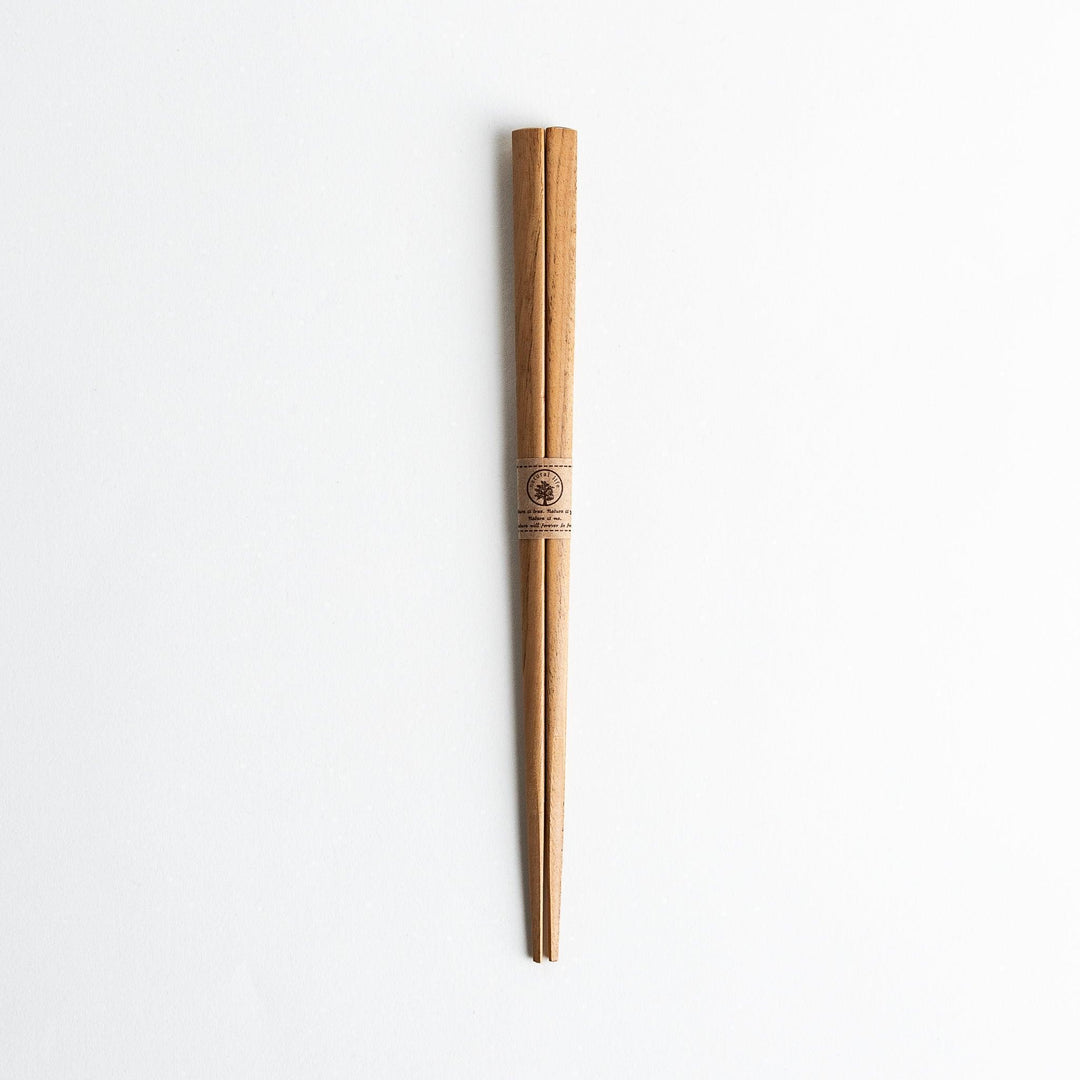 Three pairs of natural chestnut wood chopsticks, each with a different geometric shape—triangle, hexagon, and round.