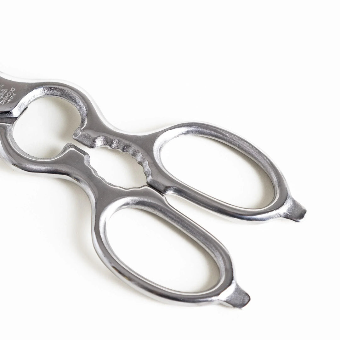 Close-up of the ergonomic silver handle on kitchen shears, featuring a smooth finish for a secure and comfortable grip.