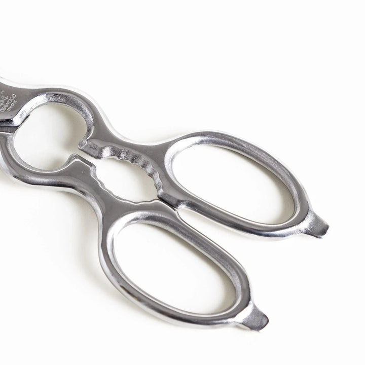 Close-up of the ergonomic silver handle on kitchen shears, featuring a smooth finish for a secure and comfortable grip.