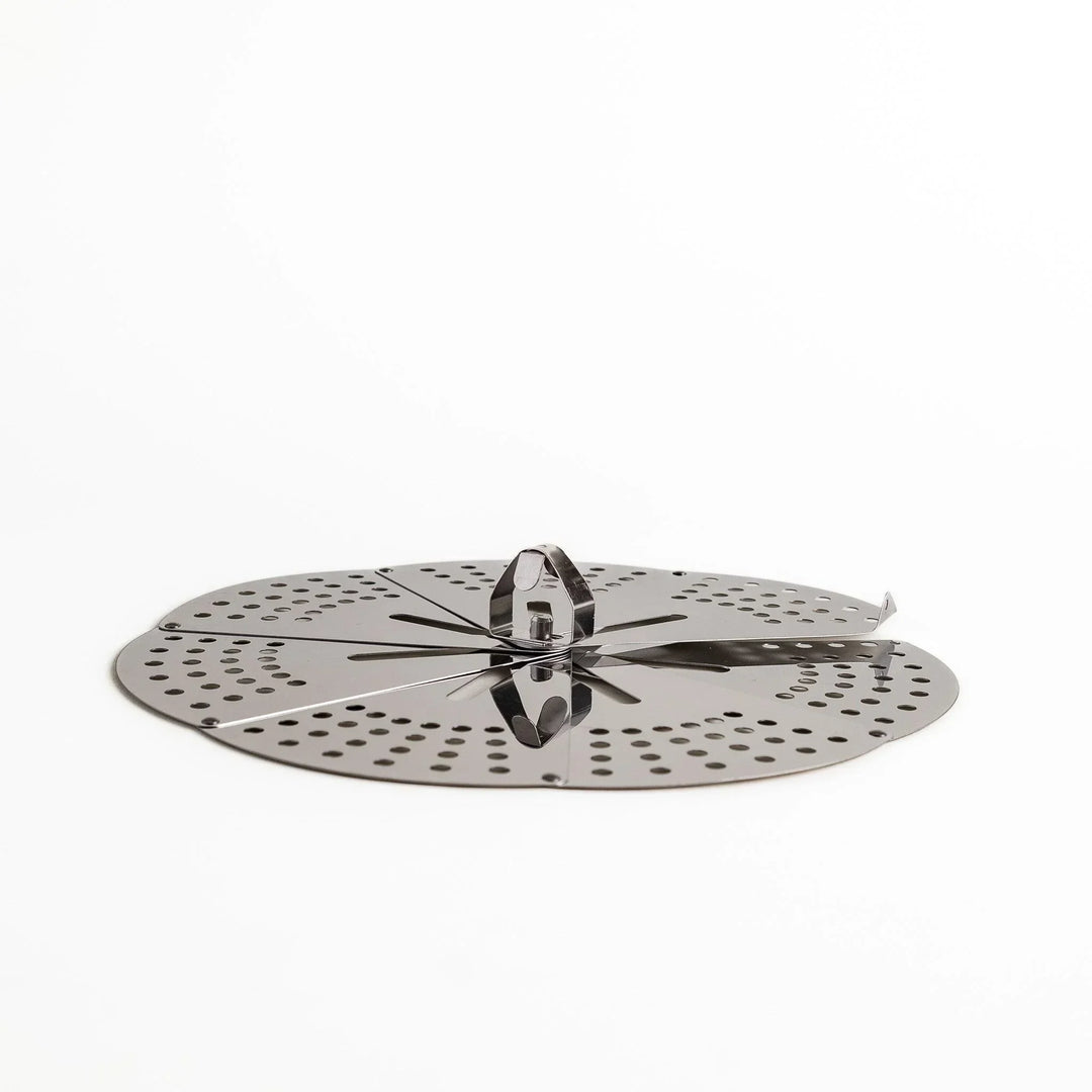 Adjustable stainless steel drop lid with foldable petals for steaming simmering and boil over control.