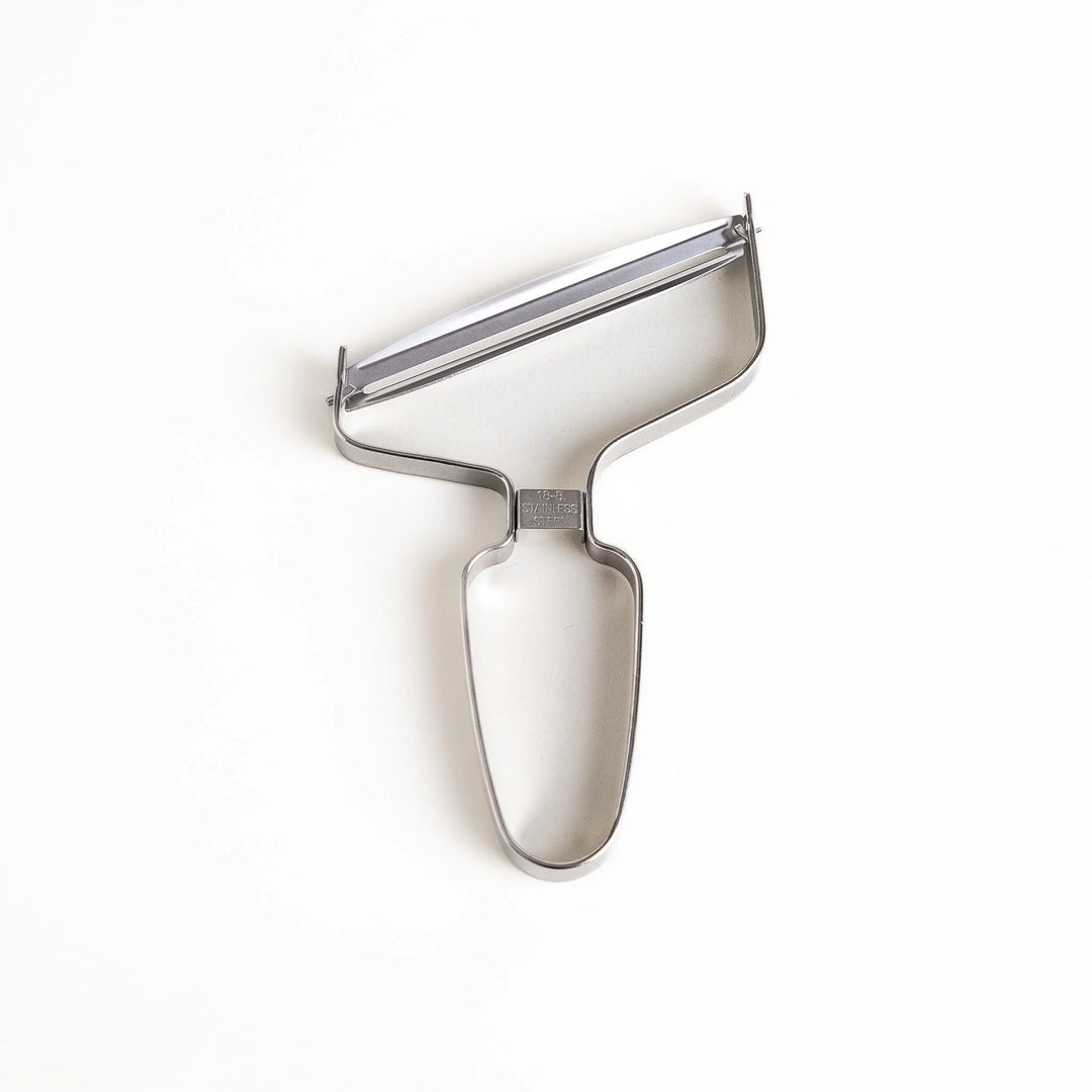 Stainless steel peeler with sharp blade and ergonomic handle for peeling fruits and vegetables easily.