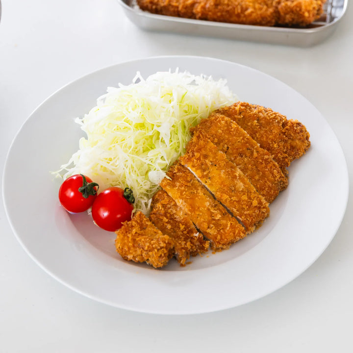 A plate of tonkatsu with finely shredded cabbage, highlighting thin julienne texture.