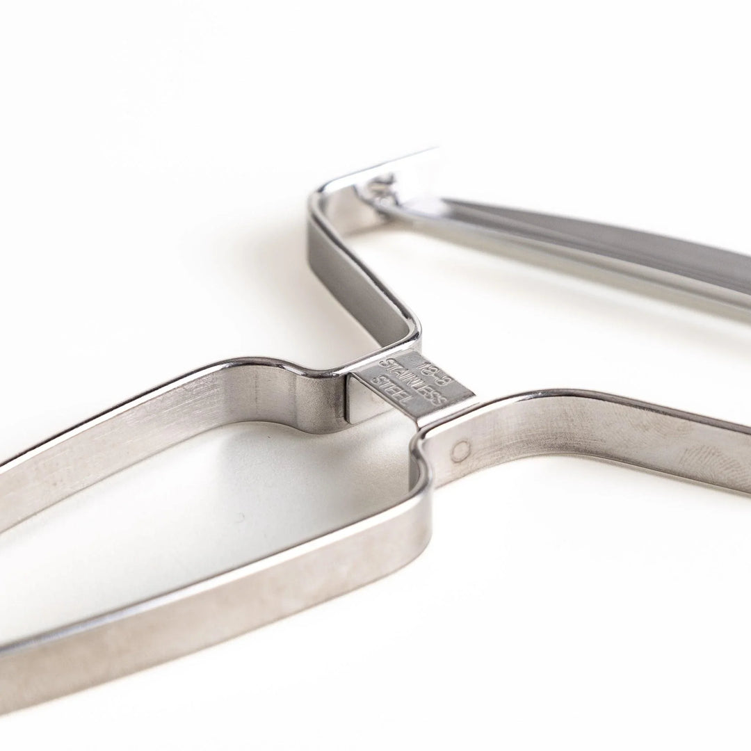 Stainless steel peeler with sharp blade and ergonomic handle for peeling fruits and vegetables easily.