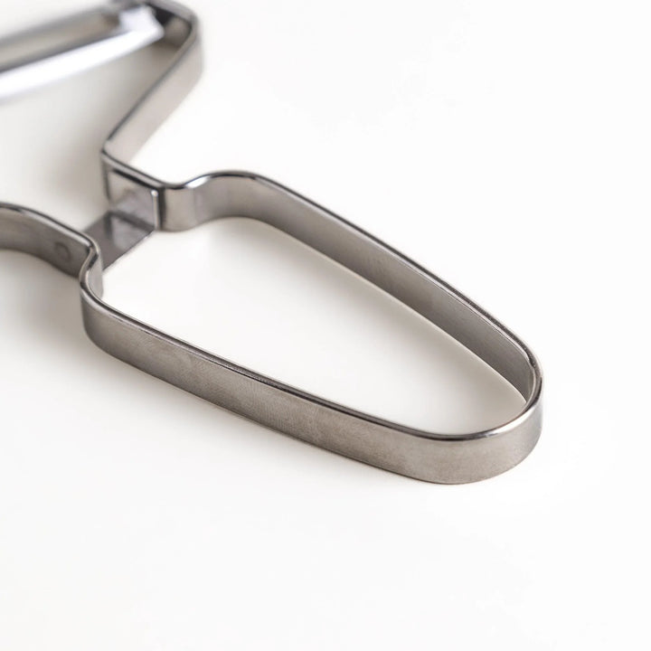 Stainless steel peeler with sharp blade and ergonomic handle for peeling fruits and vegetables easily.