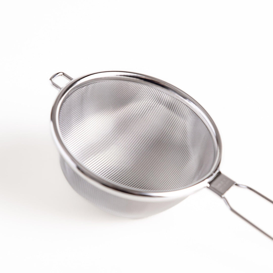 Stainless steel tea strainer with a fine mesh and a long handle, an essential kitchenware tool for brewing loose leaf tea.
