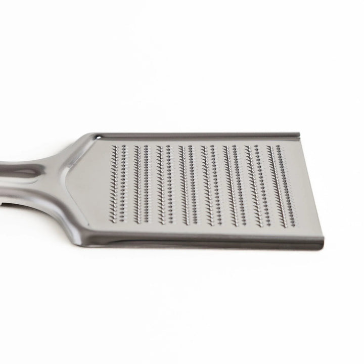 Stainless steel grater with sharp blades and ergonomic handle ideal for cheese vegetables and spices.