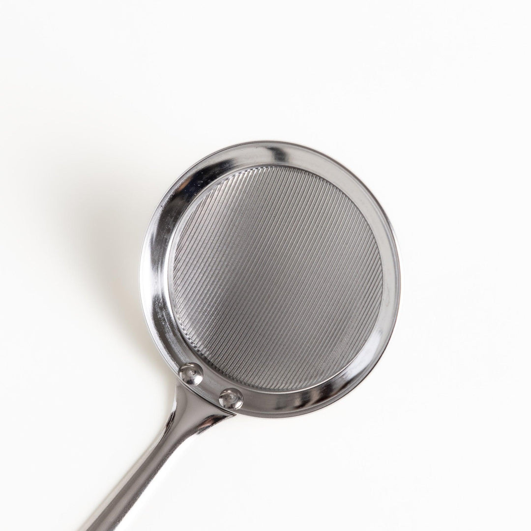 Stainless steel skimmer with fine mesh and long handle perfect for removing scum from soups or broths.