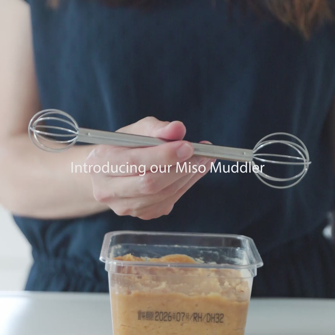 Nami from Just One Cookbook using stainless steel miso muddler to dissolve miso paste into hot soup in a pot