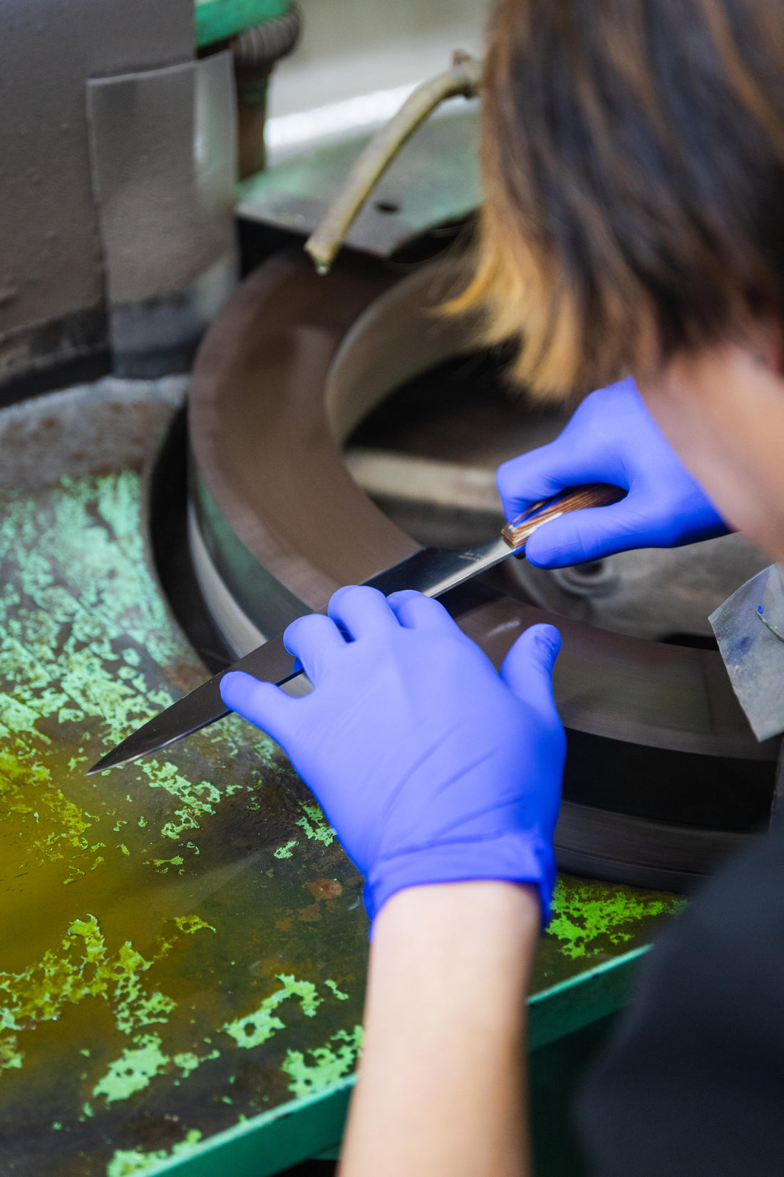 Japanese Nagome kitchen knife being sharpened by Mitsuboshi Cutlery craftsman in Sakai Japan showing traditional blade finishing