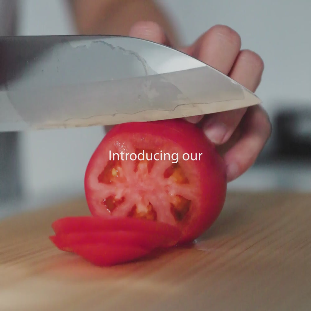 Japanese Kurotori kitchen knife being hand sharpened by a skilled craftsman in a traditional workshop highlighting sharp edge