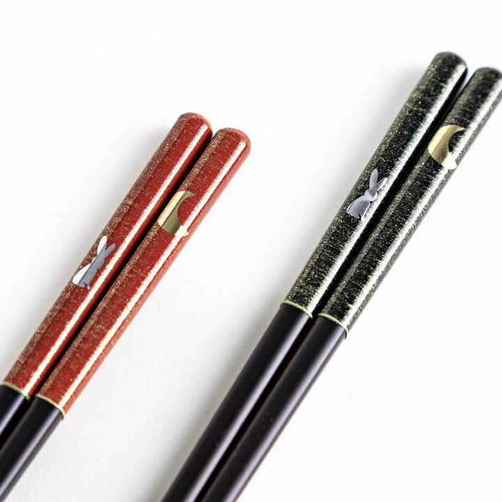 Boxed set of two Japanese chopstick pairs with red and green rabbit and moon patterns on the handles.