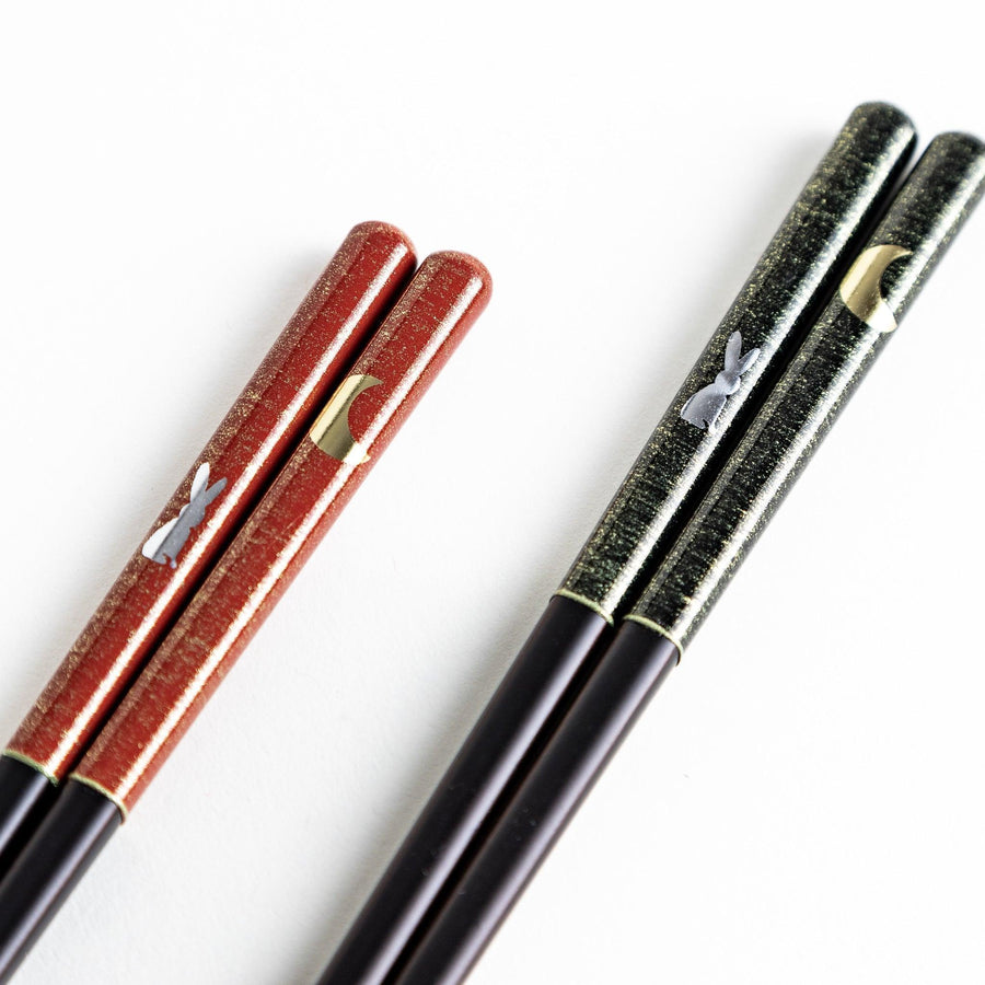 Boxed set of two Japanese chopstick pairs with red and green rabbit and moon patterns on the handles.