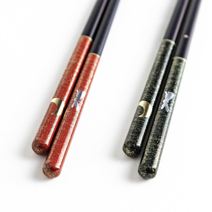 Boxed set of two Japanese chopstick pairs with red and green rabbit and moon patterns on the handles.