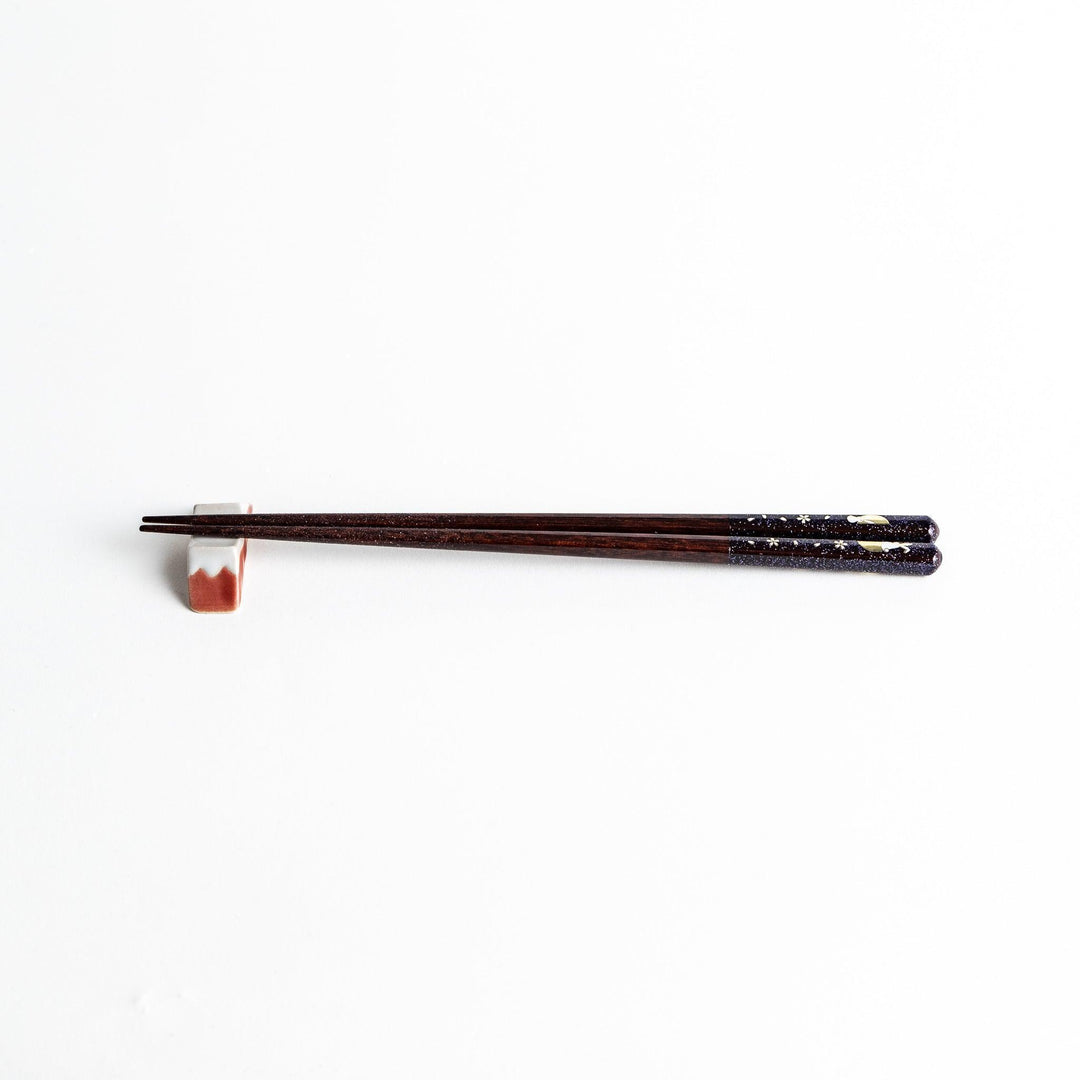 A pair of lacquered chopsticks adorned with floral patterns and rabbit. Available in purple or red.