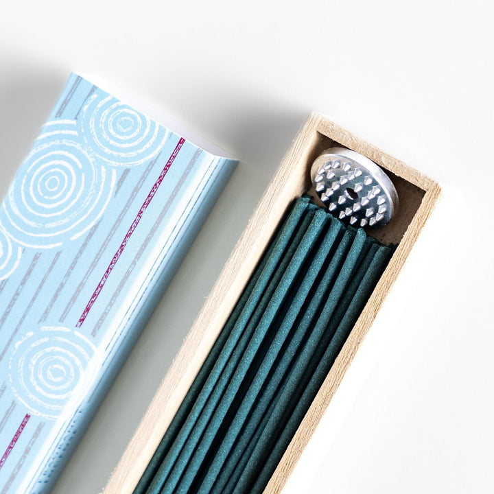 Japanese jasmine incense in wooden box with teal sticks and white circle pattern design for fresh floral scent.