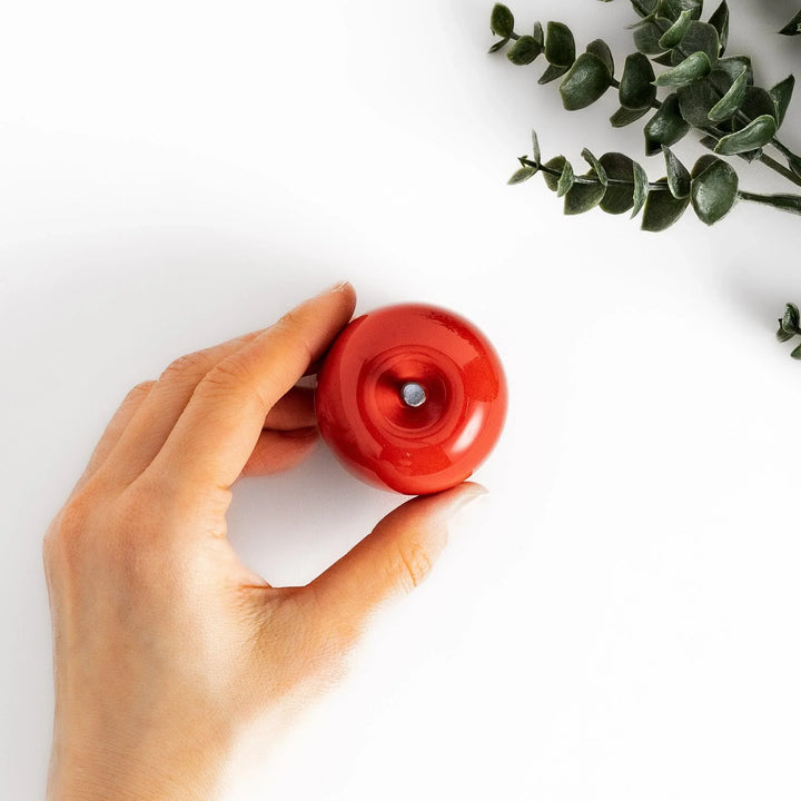Red apple shaped ceramic condiment bowl with glossy finish and lid perfect for sauces or condiments.