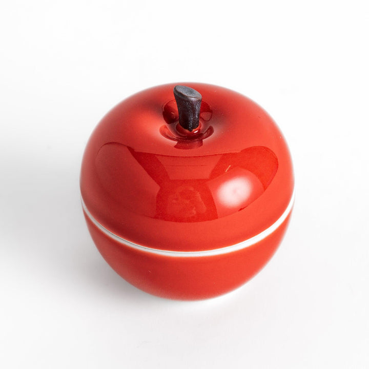 Red apple shaped ceramic condiment bowl with glossy finish and lid perfect for sauces or condiments.