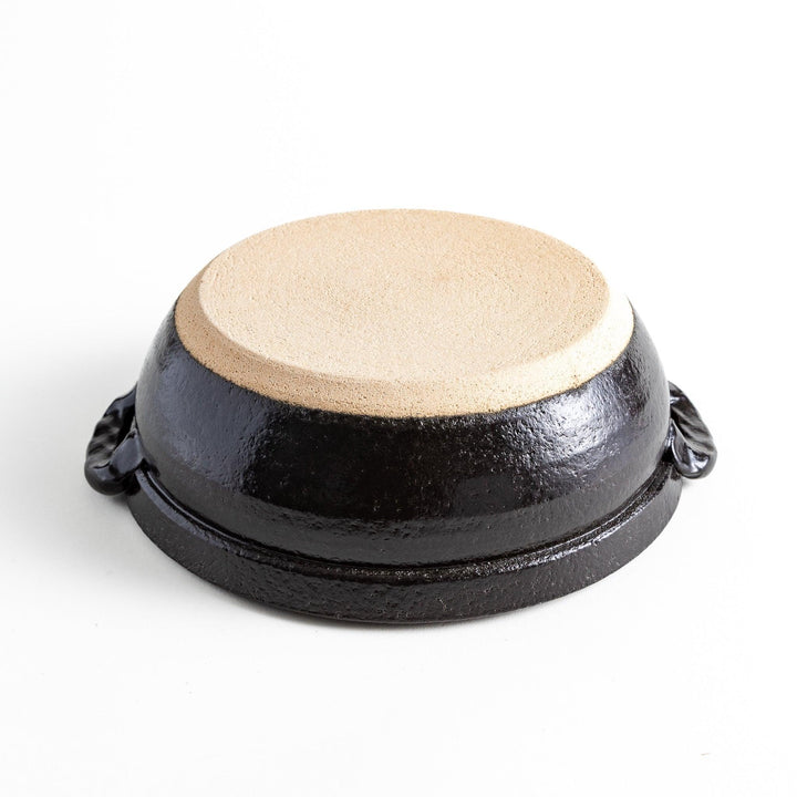 A 8-inch donabe with a vibrant black floral pattern lid and black pot.