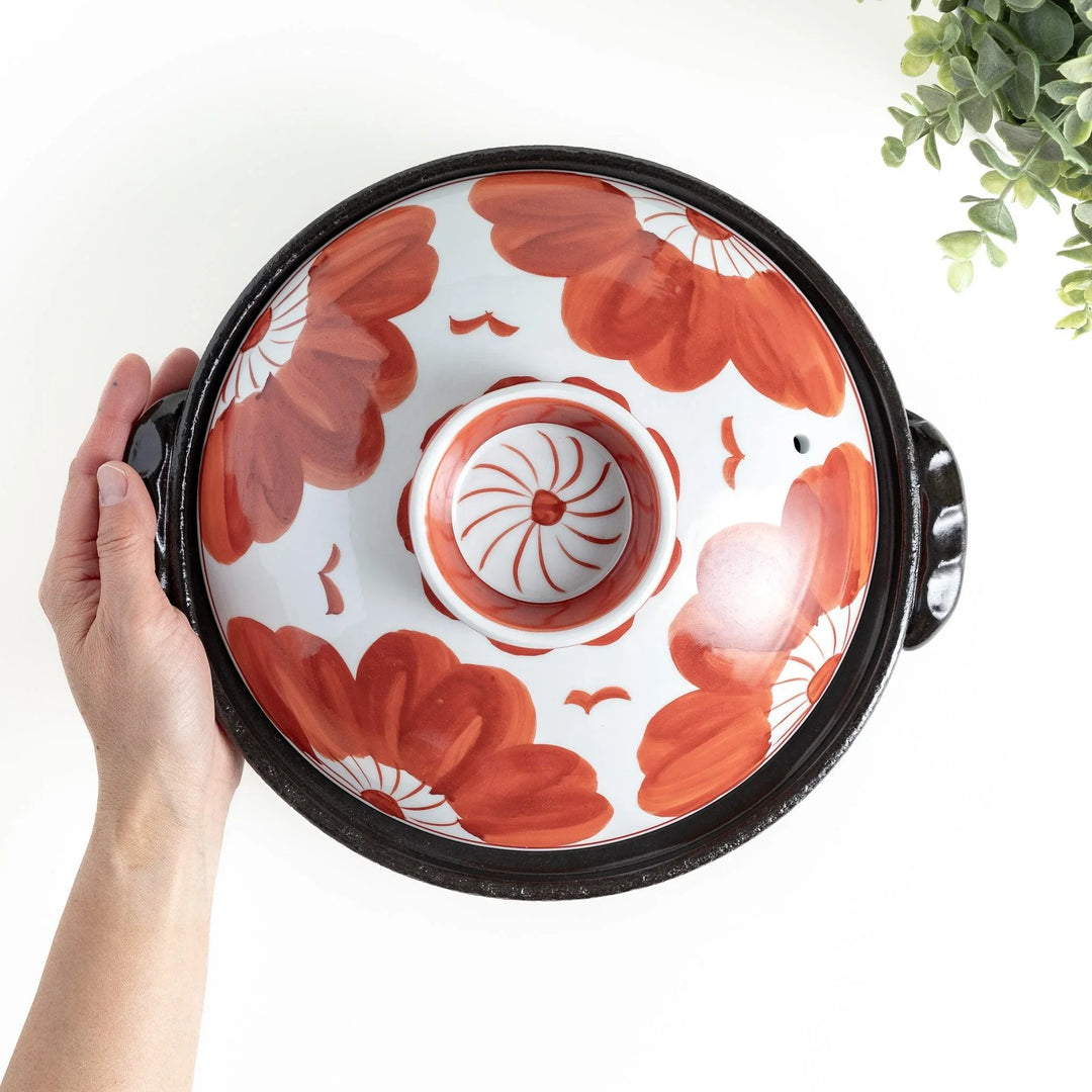 A 8-inch donabe with a vibrant black floral pattern lid and black pot.