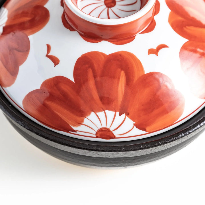 A 8-inch donabe with a vibrant black floral pattern lid and black pot.