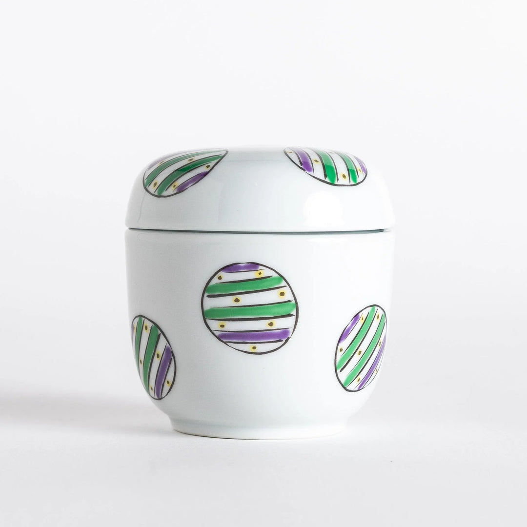 White bowl with a colorful pattern of alternating green and purple striped circles on the exterior.