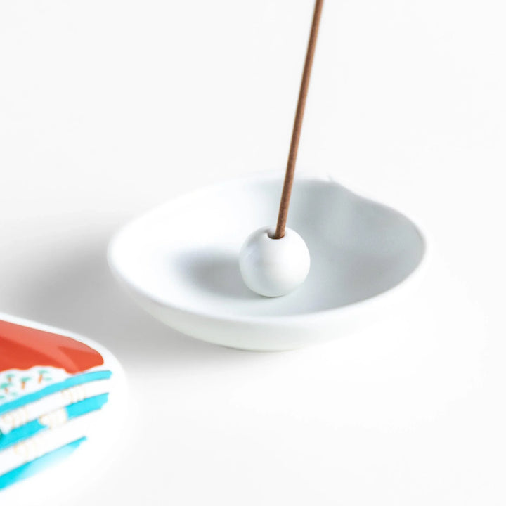 White ceramic seashell incense holder with red Mount Fuji and gold accents for elegant Japanese decor.