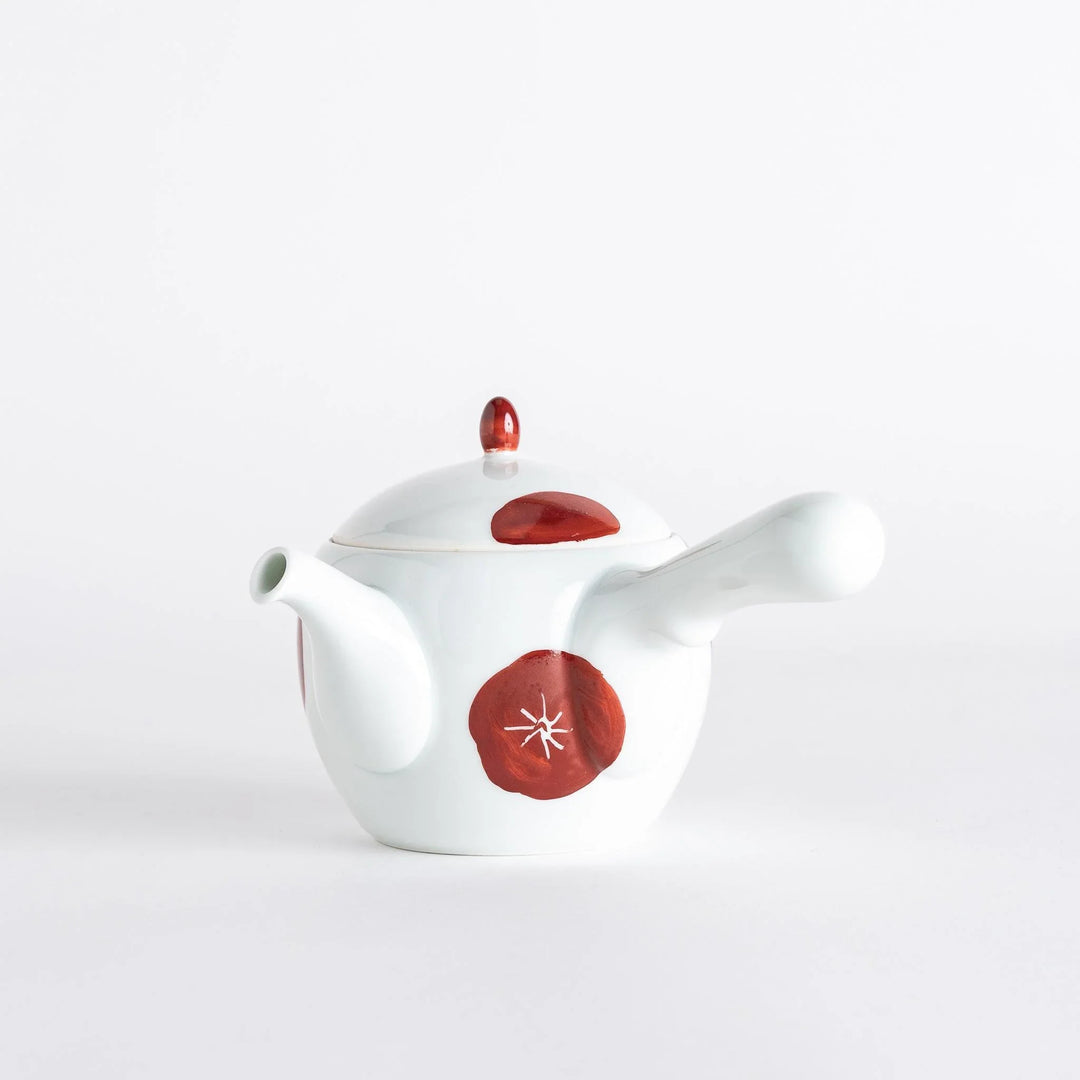 White teapot with red plum blossom design matching lid and handle blending tradition and modern elegance.