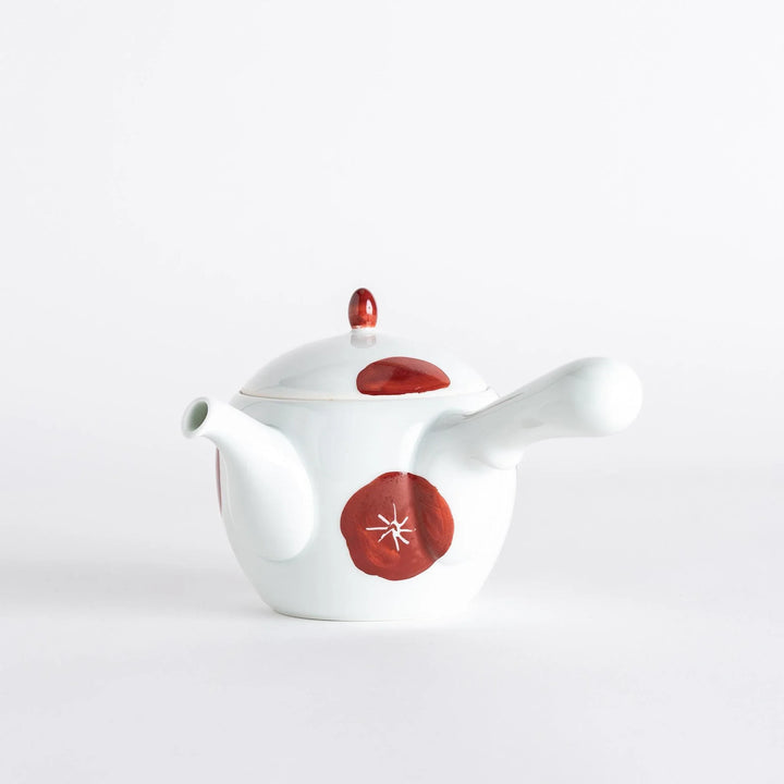 White teapot with red plum blossom design matching lid and handle blending tradition and modern elegance.