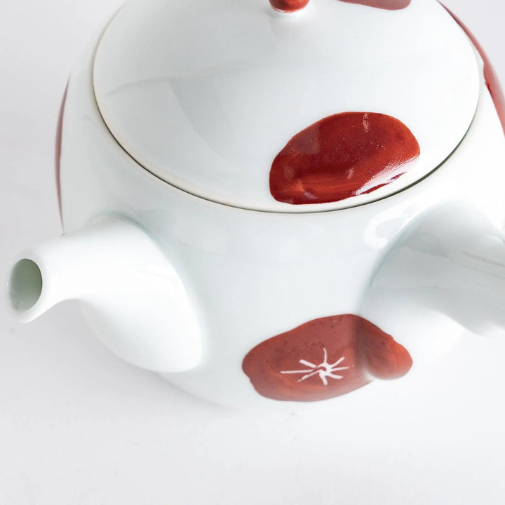 Close-up of the teapot's spout and lid, emphasizing the artistic red detailing and overall craftsmanship.