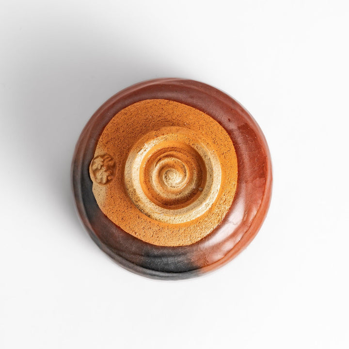 Rustic Raku ware Matcha bowl with a unique textured glaze and a striking black and red design.