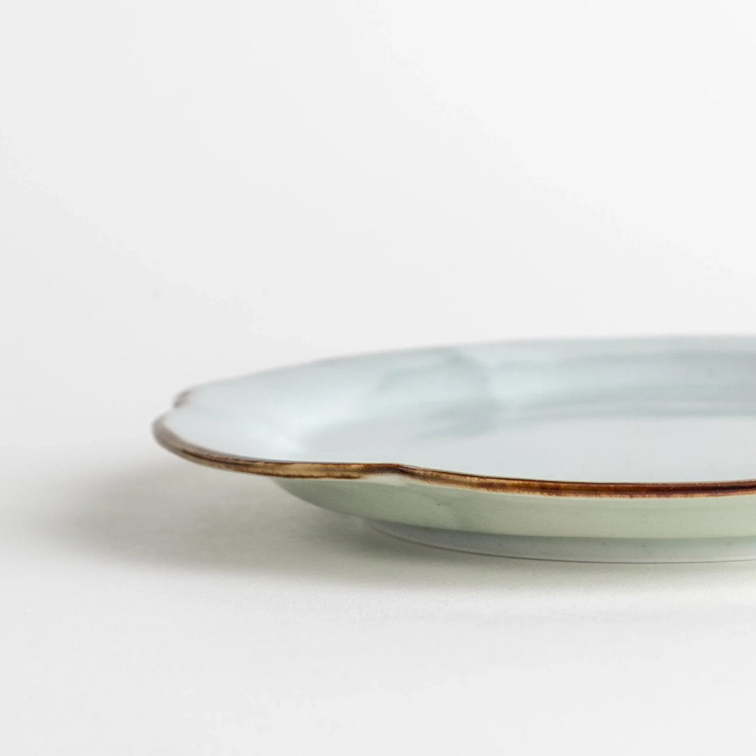 Earthy tones of olive, caramel, or off-white dessert plate, with a soft, rounded shape and subtle color variations.