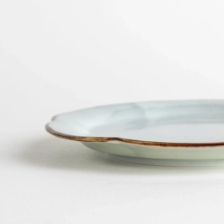 Earthy tones of olive, caramel, or off-white dessert plate, with a soft, rounded shape and subtle color variations.