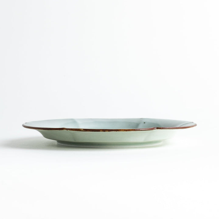 Earthy tones of olive, caramel, or off-white salad plate, with a soft, rounded shape and subtle color variations.