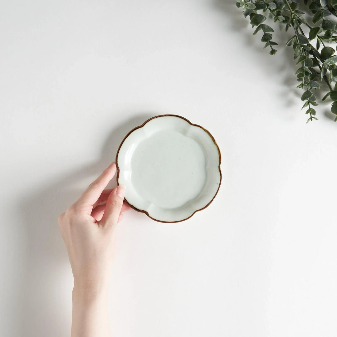 Small flower-shaped sauce dish in green, brown, and white.