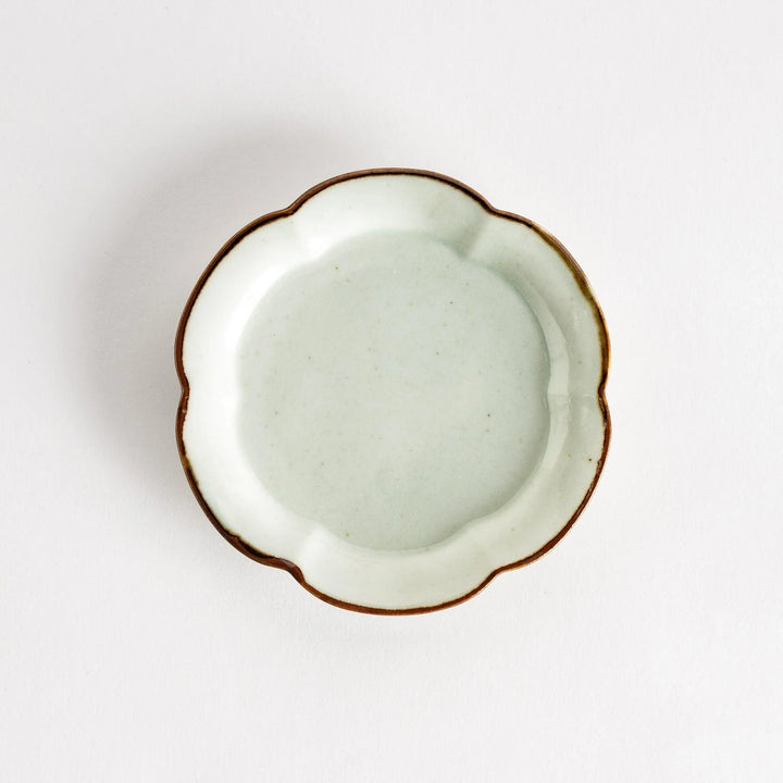 Small flower-shaped sauce dish in green, brown, and white.