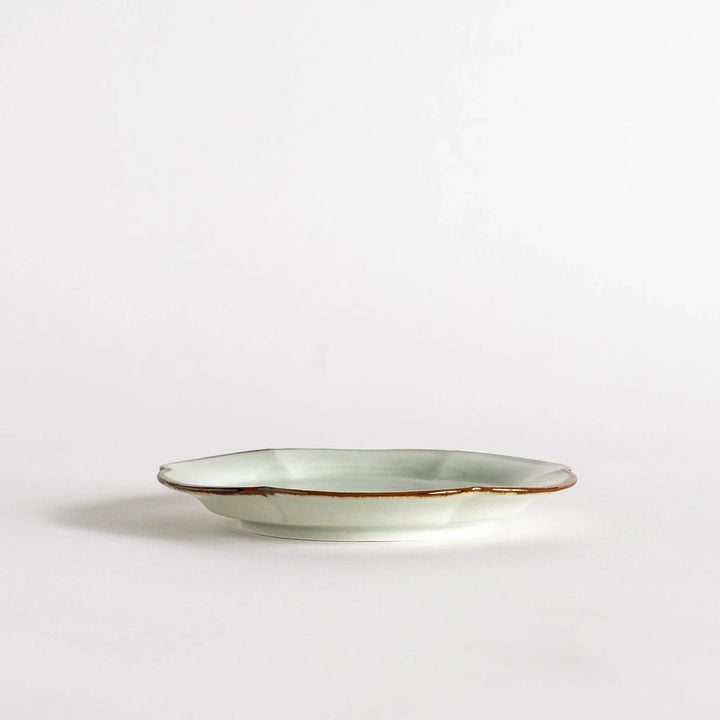 Small flower-shaped sauce dish in green, brown, and white.