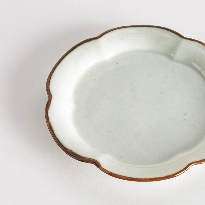 Small flower-shaped sauce dish in green, brown, and white.