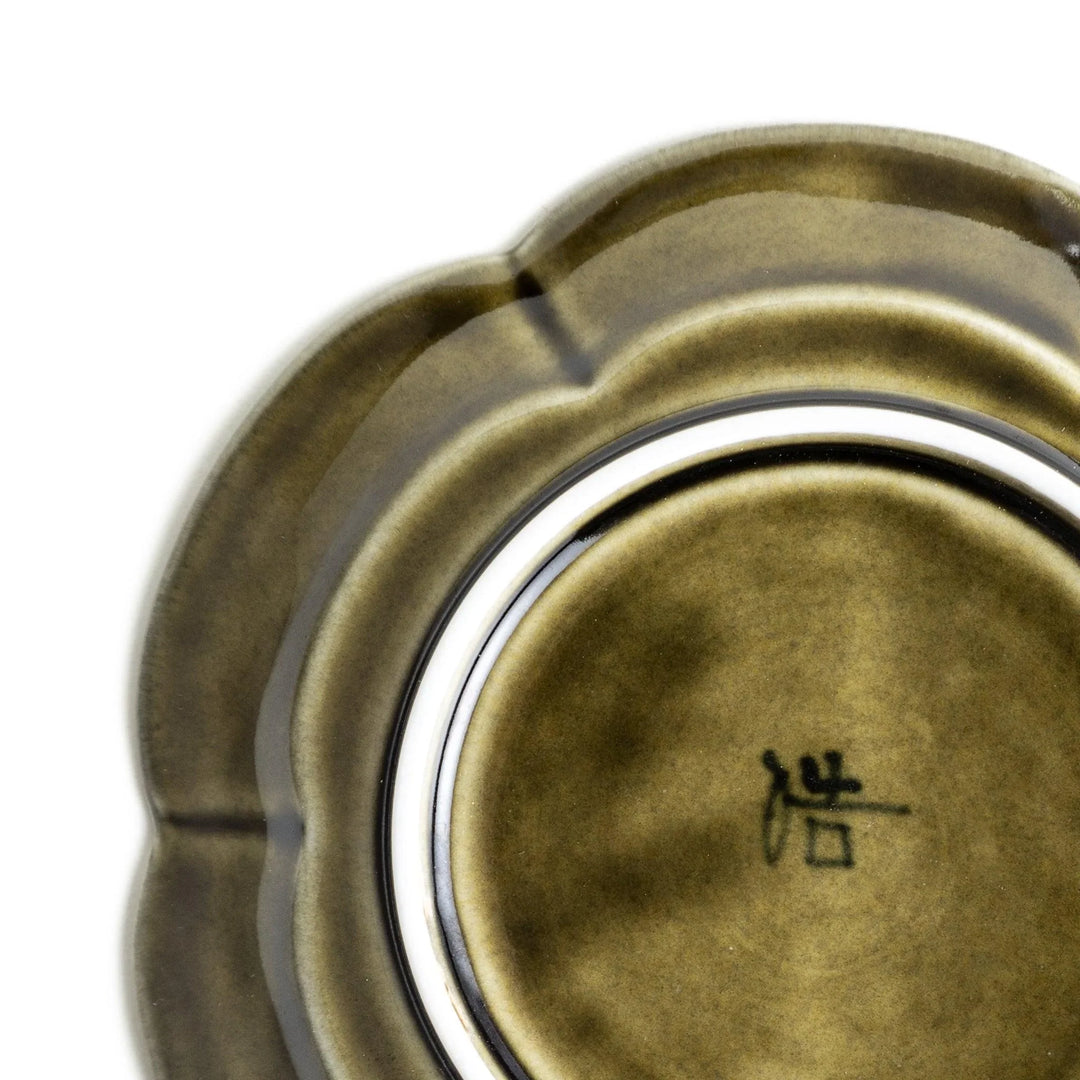 Small flower-shaped sauce dish in green, brown, and white.